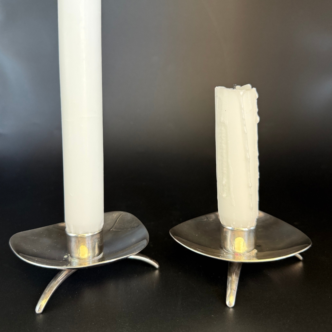 Two Vintage Cohr Denmark candle holders with white candles on a dark background