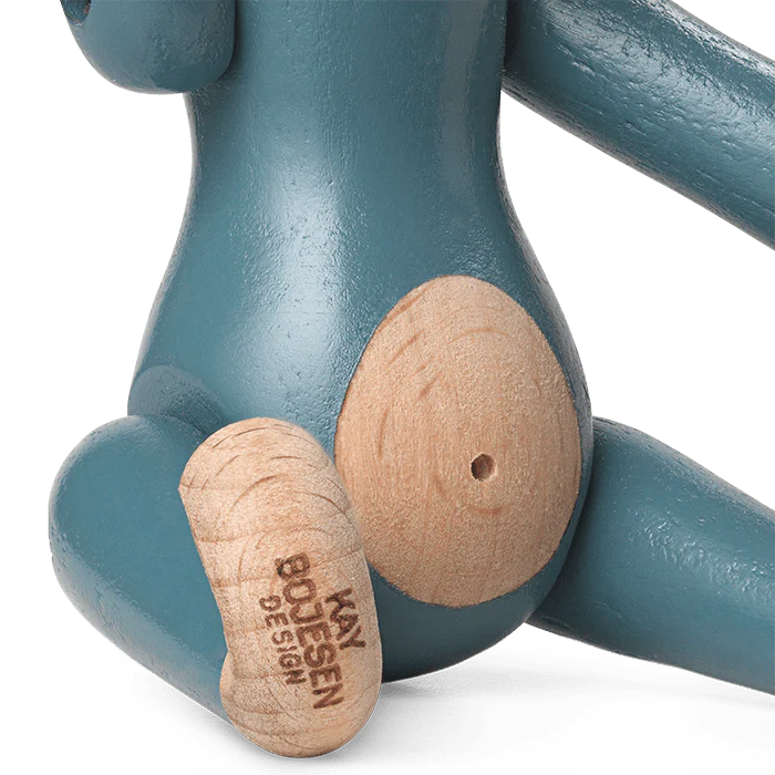 Teal and wooden toy figure with 'Kay Bojesen Design' branding on a white background