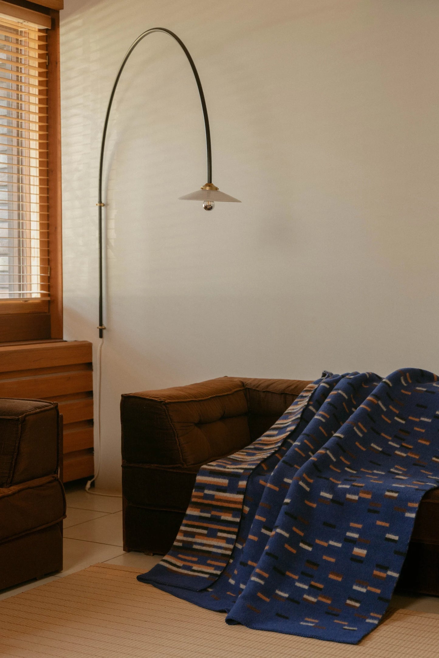 Lapuan Kankurit Yllätys Blanket on a brown sofa