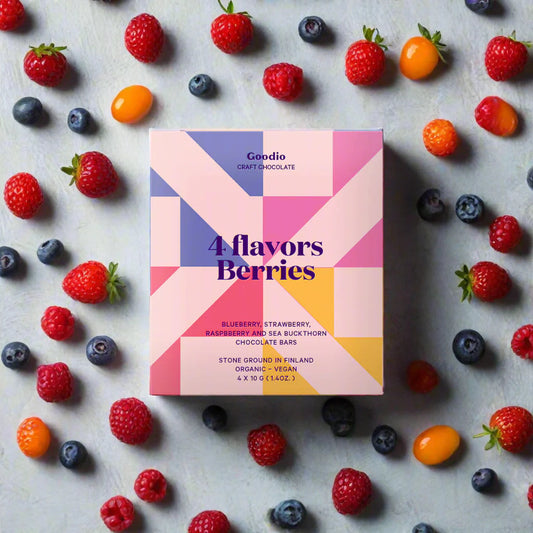 Goodio 4 Flavors Berries chocolate box surrounded by fresh berries on a light background