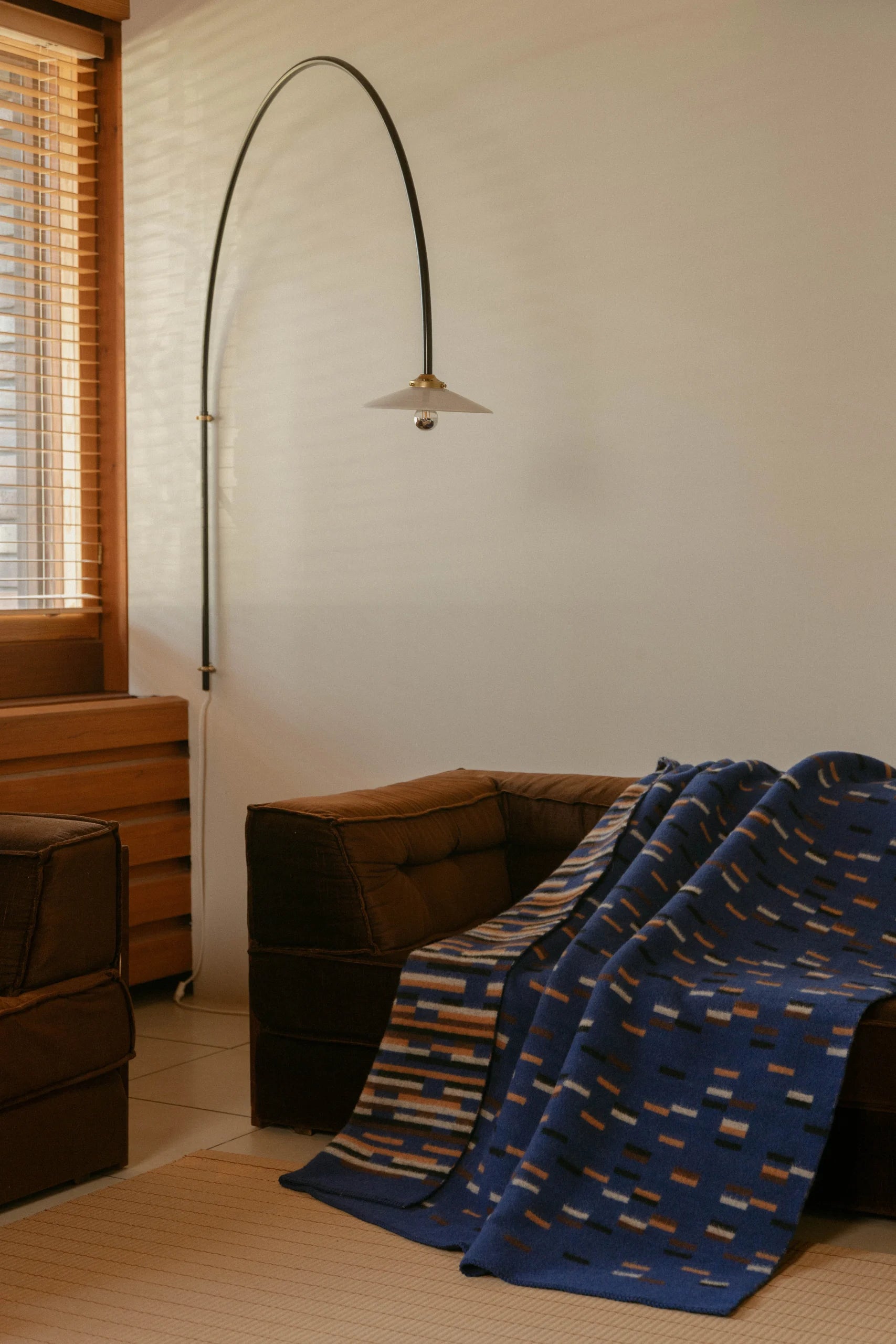 Lapuan Kankurit Yllätys Blanket on a brown sofa