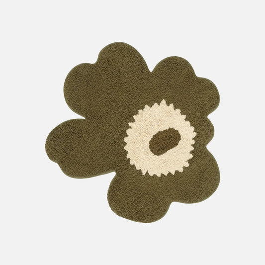 Floral-shaped rug with a green outer petal and white center on a light beige background