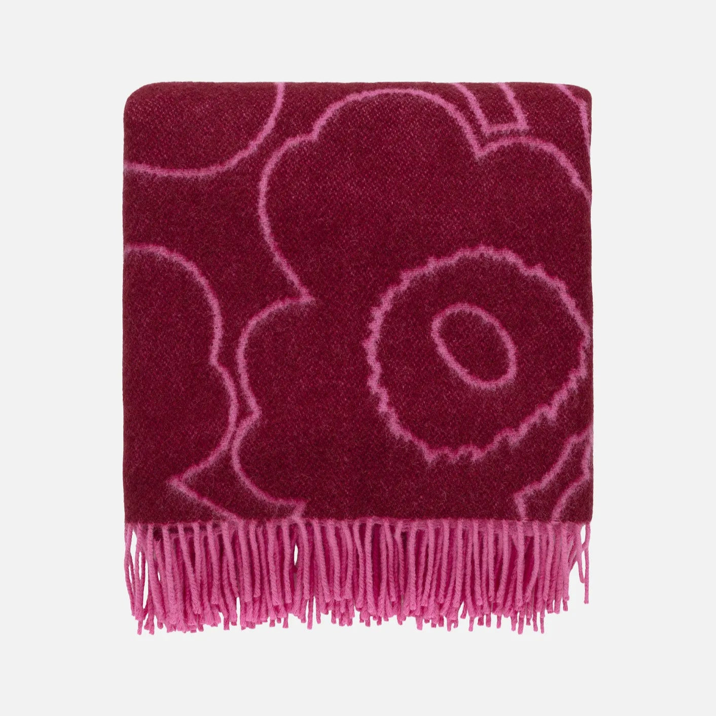 Pink floral patterned throw blanket with fringe on a white background. Marimekko Piirto Unikko Throw Blanket.