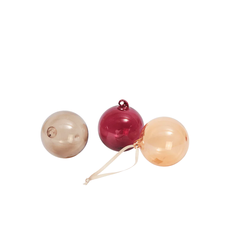 Three round ornaments in beige, red, and pink on a white background