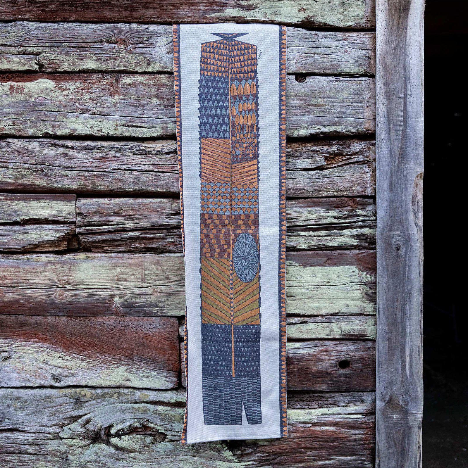 Woven cotton table runner in natural colors featuring a large fish design by Ekelund Weavers