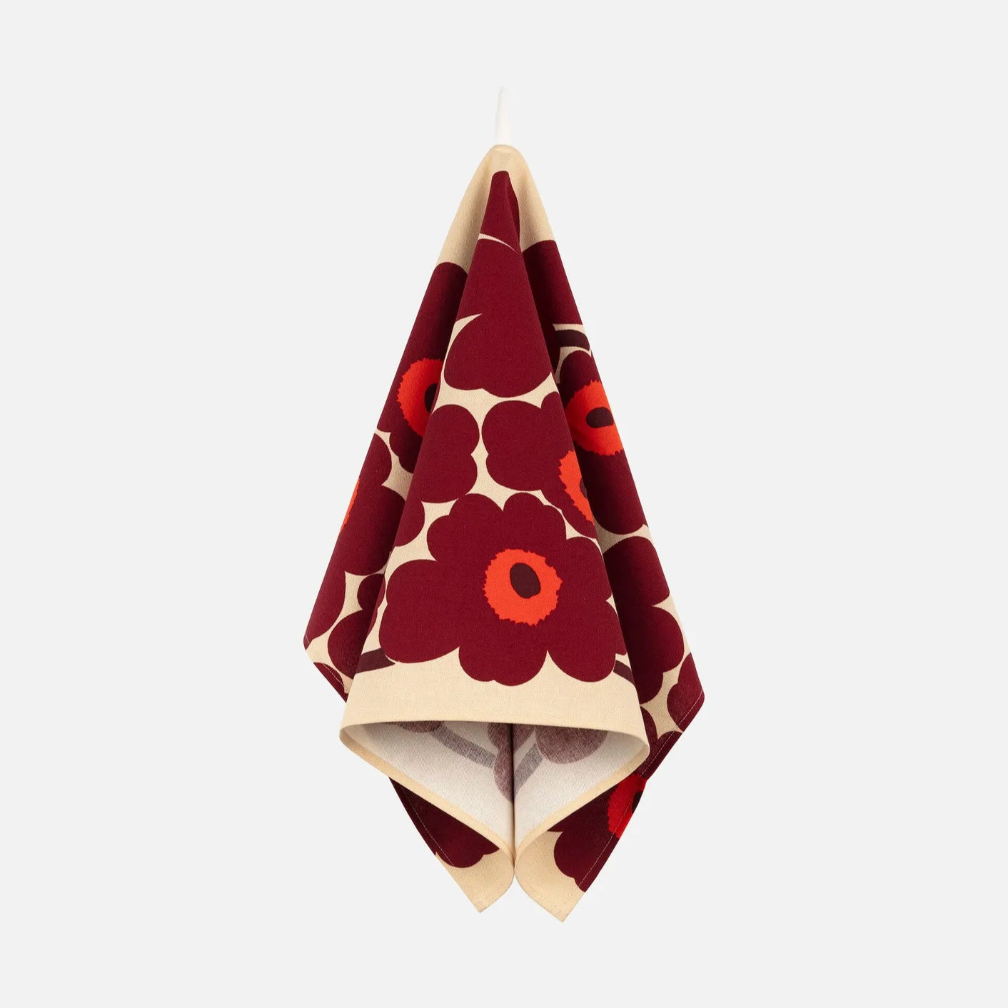 Red and white floral patterned towel hanging on a white background