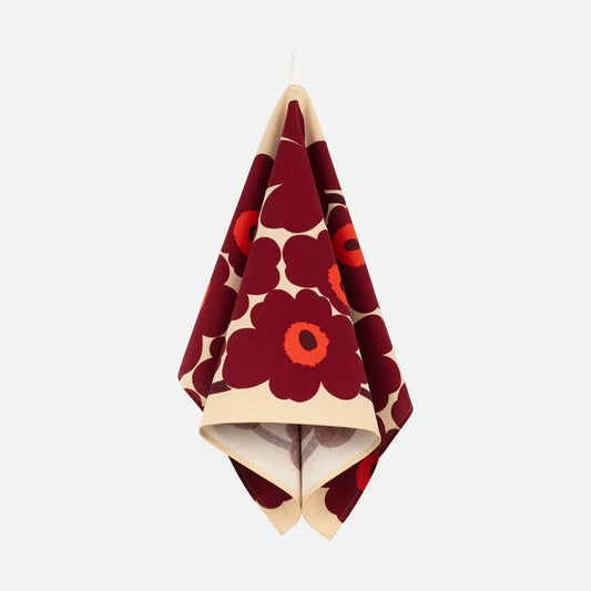 Red and white floral patterned towel hanging on a white background