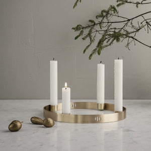 Brass ring candle holder with 4 candles. There is a tree branch and brass acorns.