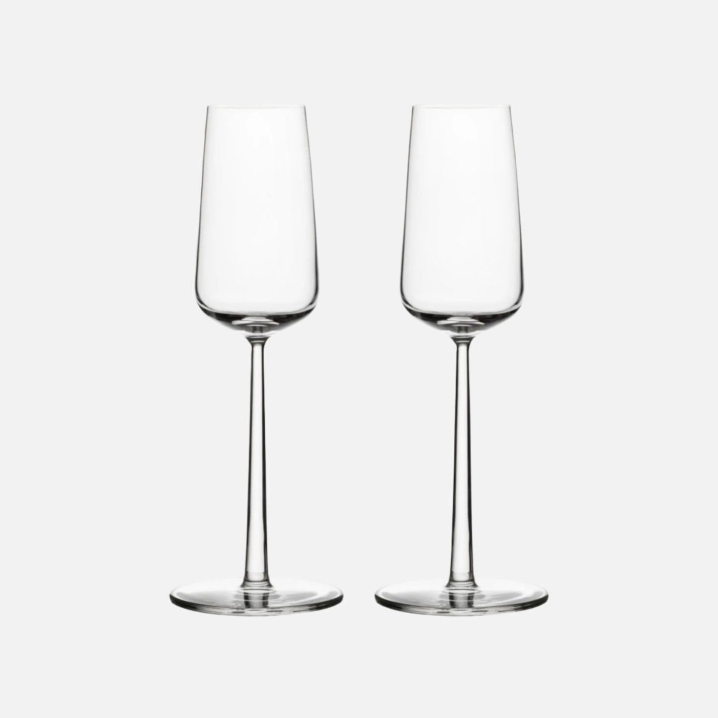 Two delicate champagne glasses against a white background.