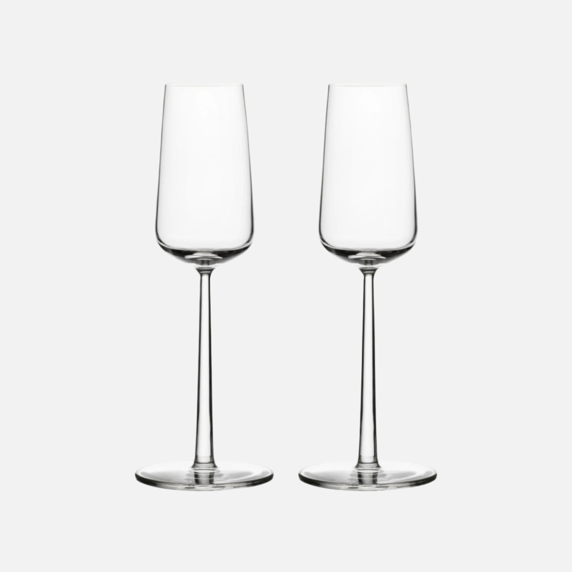 Two delicate champagne glasses against a white background.