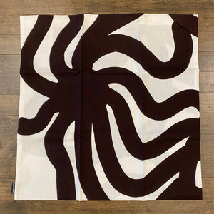 Cushion or pillow cover with a white and brown abstract pattern.