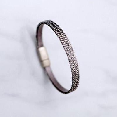 A sparkly thin bracelet with a brass clasp.