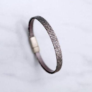 A sparkly thin bracelet with a brass clasp.