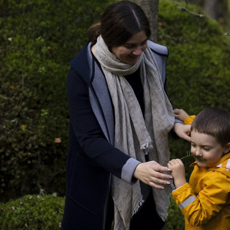 Woman wearing linen scarf playing with a young boy.